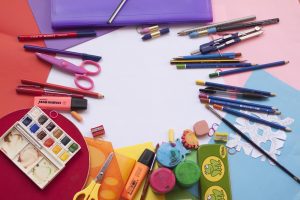 Color coordinated school supplies around a table