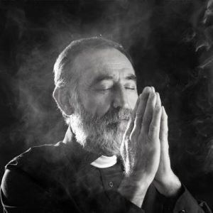 Black and white photo of a priest praying