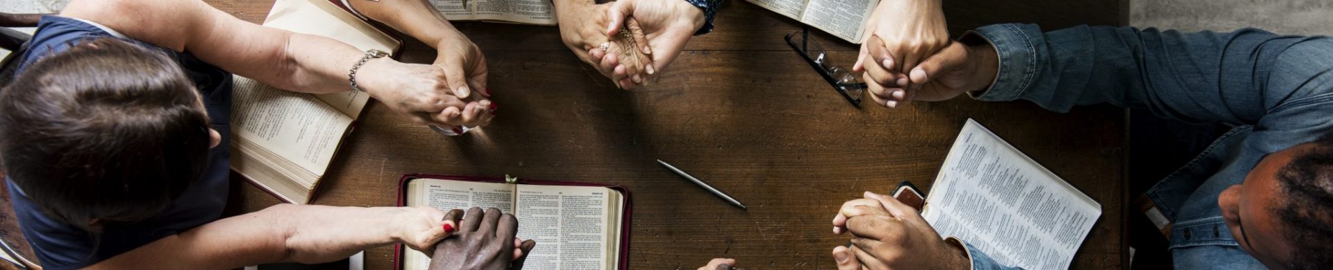 Group of people holding hands praying worship believe