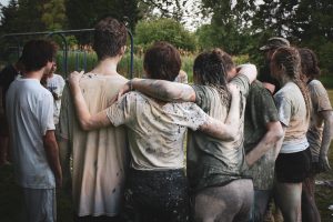 teens covered in mud in a group huddle