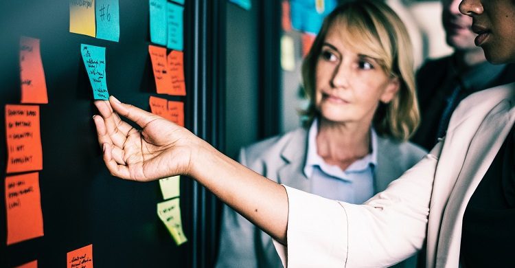 Women looking at to-do list on a whiteboard