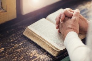 Woman holding a bible in her hands and praying