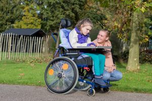 Disabled child with caregiver going for walk